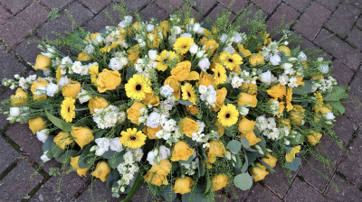 Yellow and White Coffin Spray - A beautiful yellow and white spray featuring yellow Roses, yellow Germini, and seasonal white flowers, elegantly arranged with fresh foliage.