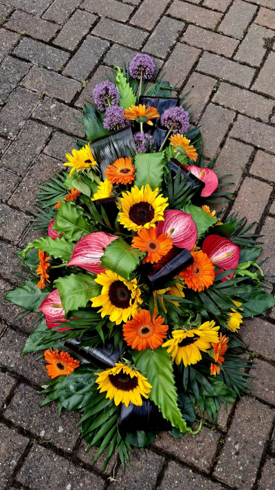 Colourful & Tropical Coffin Spray - A large Single Ended Spray of bright, colourful tropical flowers with tropical foliage.